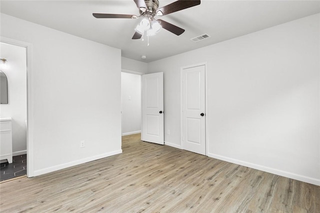 unfurnished bedroom featuring connected bathroom, ceiling fan, and light hardwood / wood-style flooring