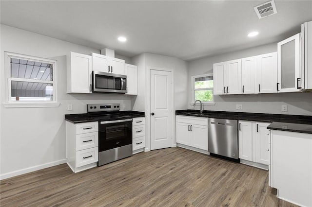 kitchen featuring sink, white cabinetry, dark wood-type flooring, and appliances with stainless steel finishes