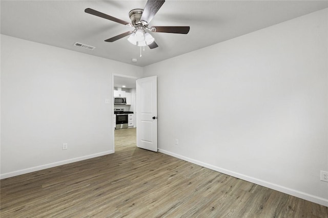 empty room featuring hardwood / wood-style flooring and ceiling fan