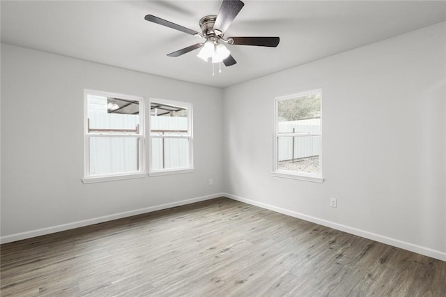 spare room with hardwood / wood-style floors, ceiling fan, and a healthy amount of sunlight