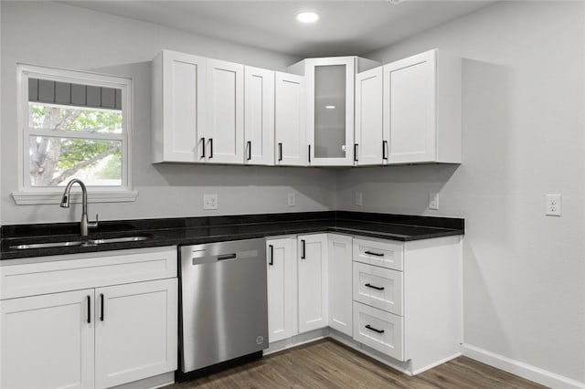 kitchen featuring stainless steel dishwasher, white cabinetry, and sink