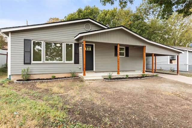 ranch-style house with covered porch and a carport