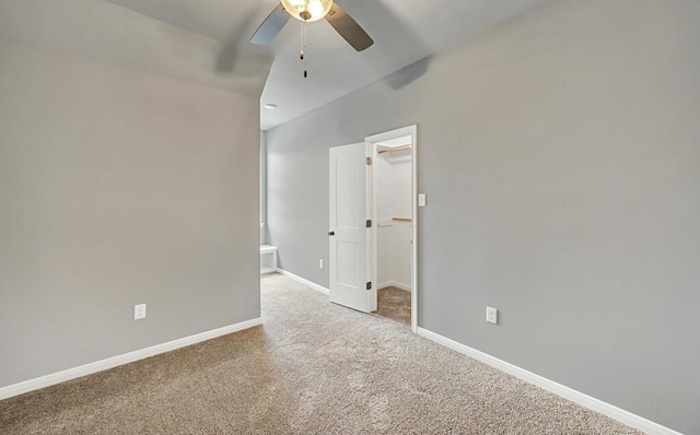 carpeted empty room featuring ceiling fan and vaulted ceiling