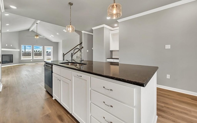 kitchen with a kitchen island with sink, sink, light hardwood / wood-style flooring, decorative light fixtures, and white cabinetry