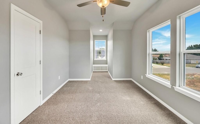 carpeted spare room featuring ceiling fan and lofted ceiling