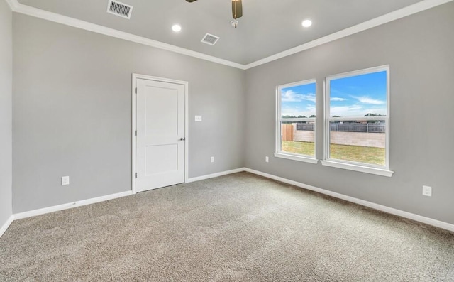 carpeted spare room featuring ceiling fan and ornamental molding