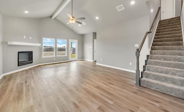 unfurnished living room with ceiling fan, beamed ceiling, high vaulted ceiling, and light wood-type flooring