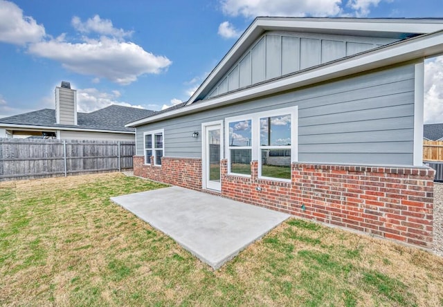 back of property with a yard and a patio