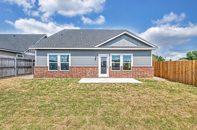 back of house with a yard and a patio