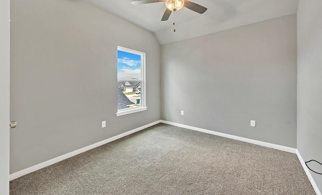 spare room featuring ceiling fan, carpet floors, and vaulted ceiling