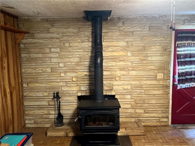 interior details featuring parquet flooring, a textured ceiling, and a wood stove