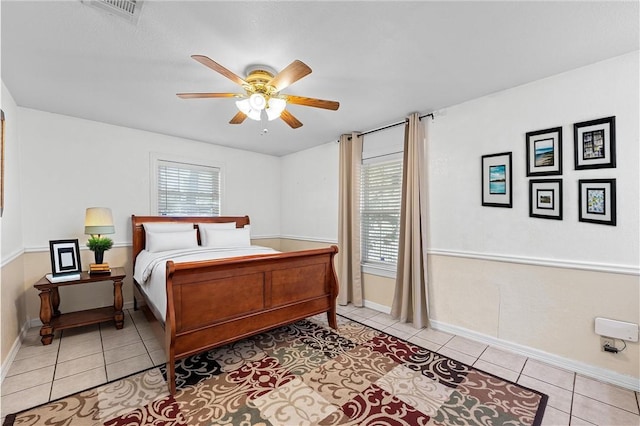 bedroom featuring multiple windows, light tile patterned floors, and ceiling fan