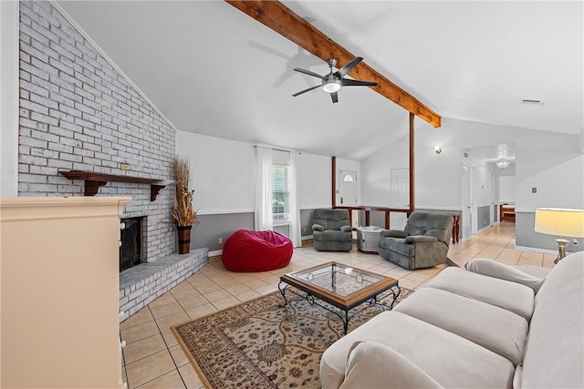 tiled living room with ceiling fan, lofted ceiling with beams, and a brick fireplace