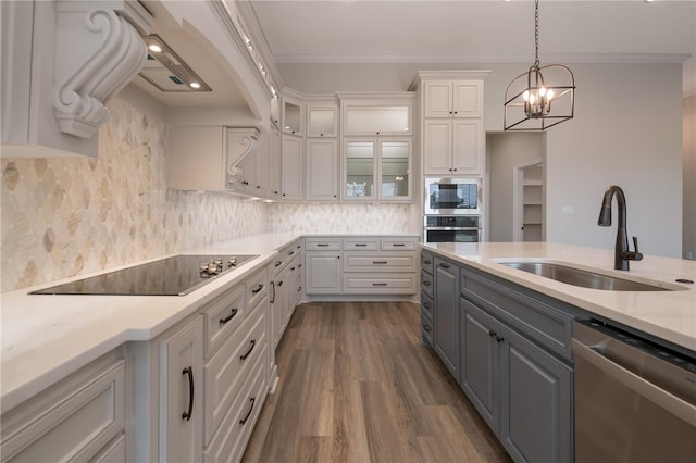 kitchen with stainless steel appliances, crown molding, sink, hardwood / wood-style flooring, and white cabinets