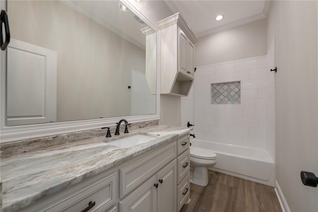 full bathroom with crown molding, wood-type flooring, toilet, vanity, and tiled shower / bath