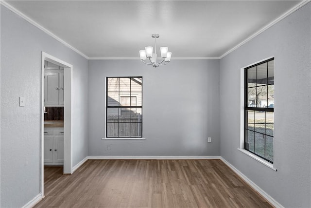 unfurnished room with crown molding, wood-type flooring, a chandelier, and a wealth of natural light