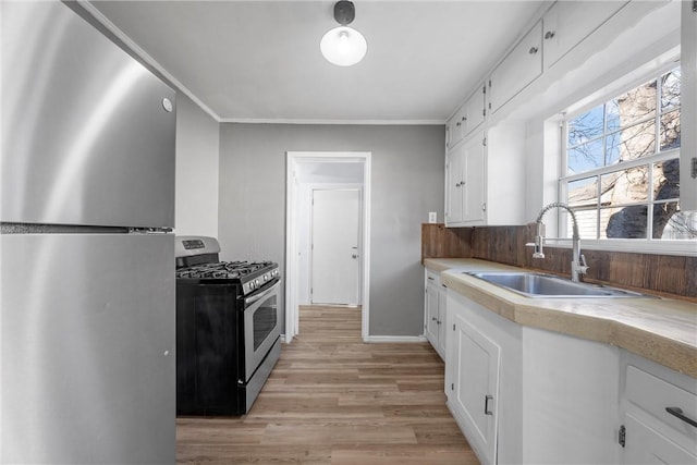 kitchen with white cabinetry, sink, light hardwood / wood-style flooring, and appliances with stainless steel finishes