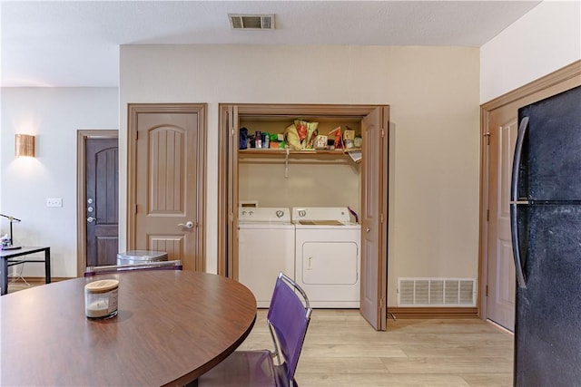 dining space featuring independent washer and dryer, light wood-style floors, and visible vents