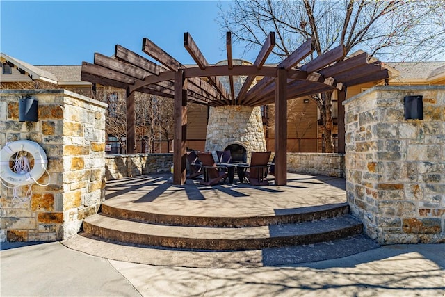 view of patio featuring an outdoor fireplace and a pergola