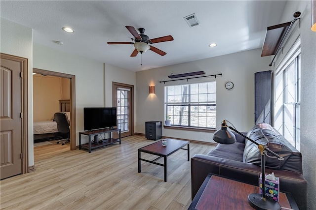 living room featuring visible vents, a ceiling fan, recessed lighting, light wood-style floors, and baseboards