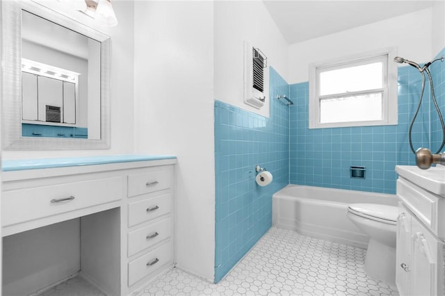 full bathroom featuring toilet, shower / washtub combination, tile walls, wainscoting, and vanity