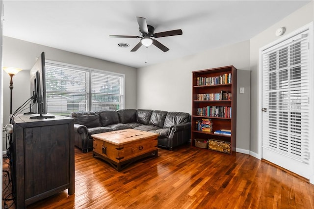 living room with visible vents, baseboards, hardwood / wood-style floors, and a ceiling fan