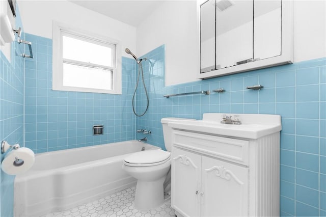 full bath with visible vents, toilet, shower / bathing tub combination, tile walls, and vanity