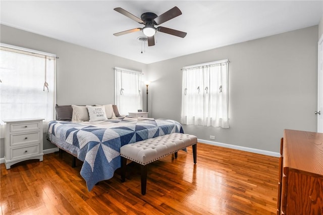 bedroom with ceiling fan, baseboards, and wood finished floors