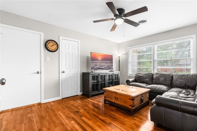 living area featuring visible vents, ceiling fan, baseboards, and wood finished floors