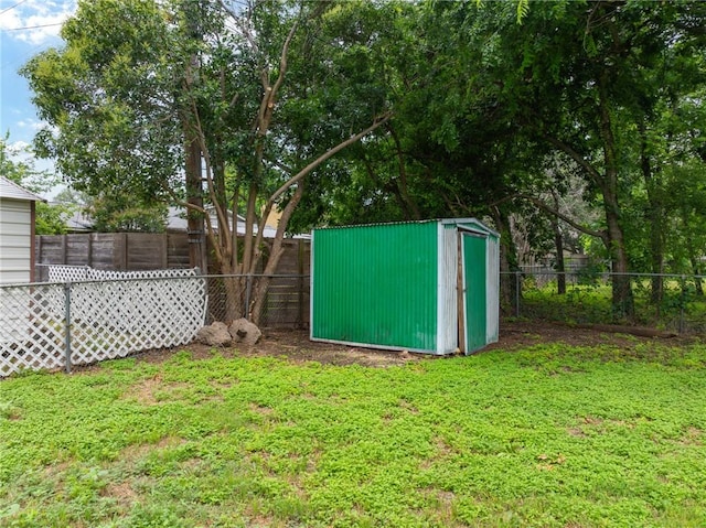 view of yard with an outbuilding, a fenced backyard, and a shed