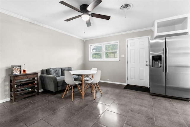 dining space with visible vents, crown molding, ceiling fan, baseboards, and dark tile patterned flooring