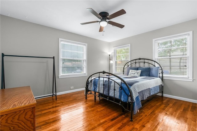 bedroom with hardwood / wood-style flooring, baseboards, and ceiling fan