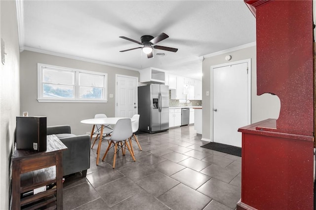 dining room featuring dark tile patterned floors, a ceiling fan, and ornamental molding