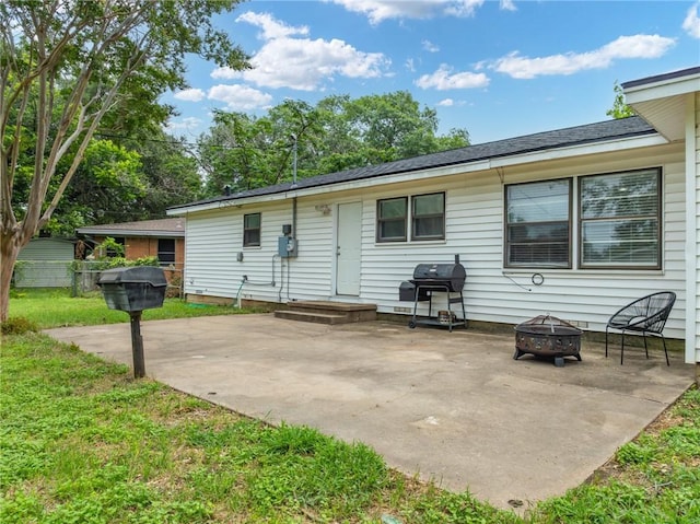 back of property featuring a patio, a lawn, and an outdoor fire pit