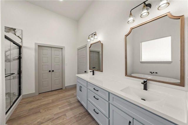 bathroom featuring vanity, wood-type flooring, lofted ceiling, and shower with separate bathtub