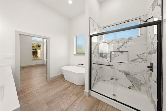 bathroom with hardwood / wood-style floors and independent shower and bath