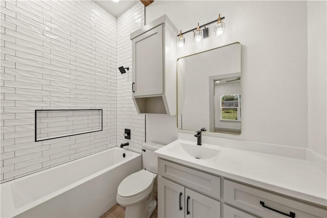 full bathroom featuring vanity, tiled shower / bath combo, and toilet