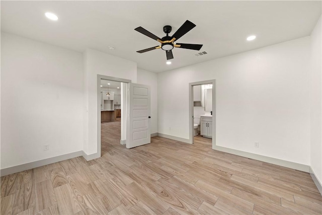 unfurnished bedroom featuring ceiling fan, light hardwood / wood-style floors, and connected bathroom