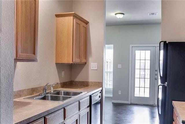 kitchen featuring black fridge, sink, and dishwasher