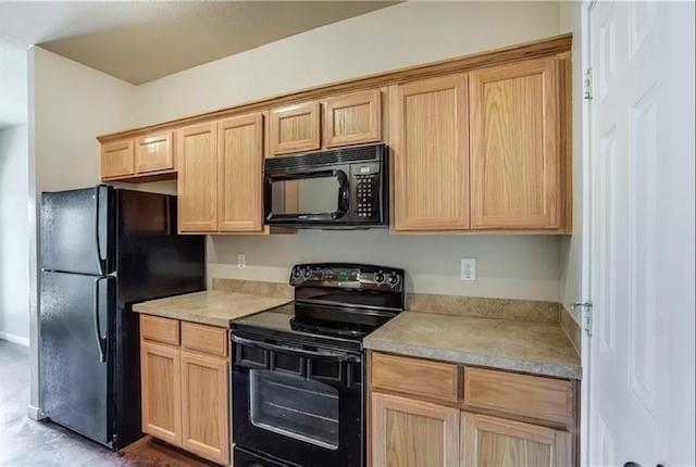 kitchen featuring light brown cabinets and black appliances