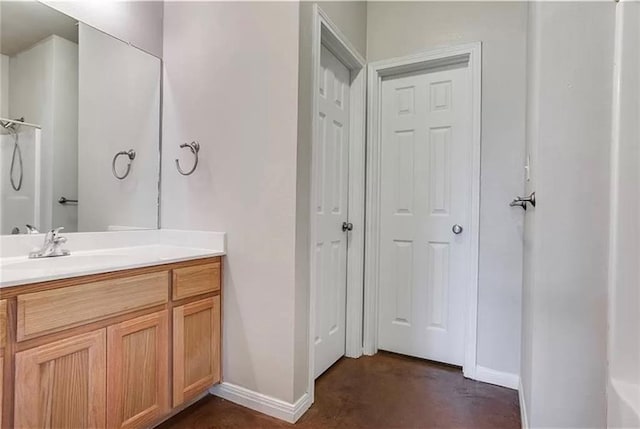 bathroom with concrete floors, a shower, and vanity