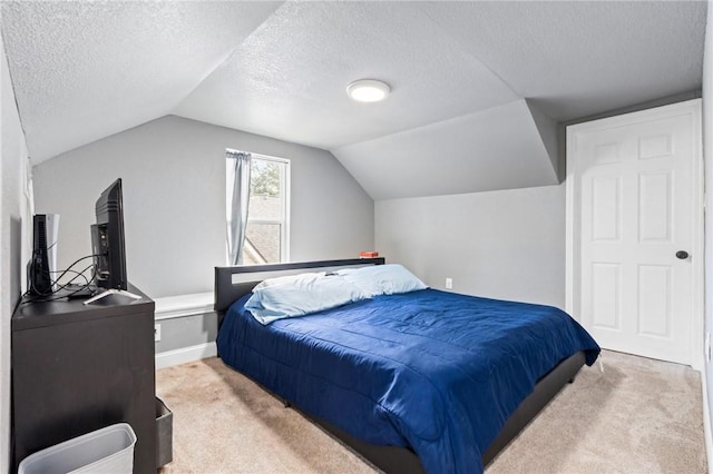 bedroom with light carpet, a textured ceiling, and vaulted ceiling