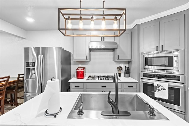 kitchen featuring gray cabinetry, sink, stainless steel appliances, and hanging light fixtures