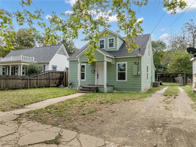 bungalow featuring a front yard and cooling unit