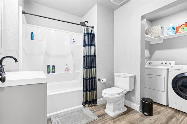 full bathroom with washer and dryer, shower / tub combo, hardwood / wood-style flooring, and toilet