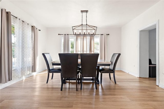 dining area featuring plenty of natural light, an inviting chandelier, and light hardwood / wood-style flooring