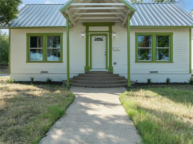 entrance to property featuring a yard