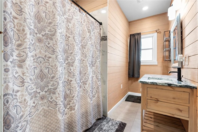 bathroom with a shower with curtain, vanity, tile patterned floors, and wooden walls