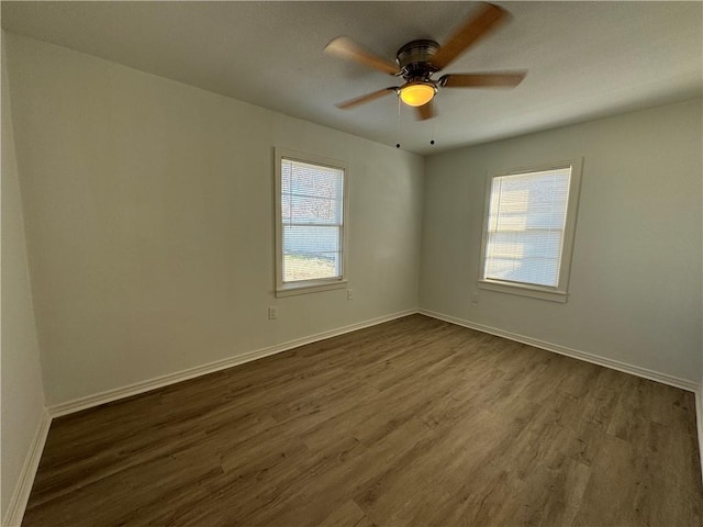 spare room with ceiling fan, plenty of natural light, and dark hardwood / wood-style flooring