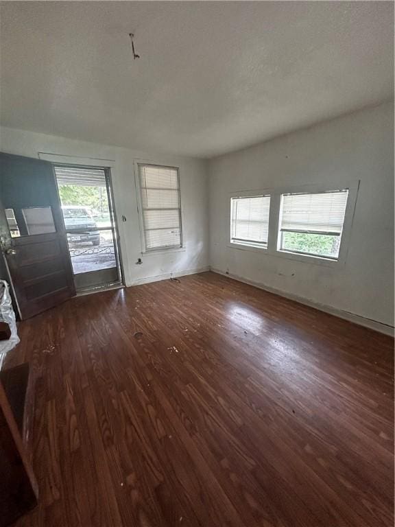 unfurnished living room with dark hardwood / wood-style floors